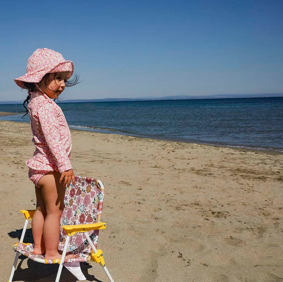 A 3 piece girls swimwear set with a top, bottom, and hat, in a lilac blossom print.
