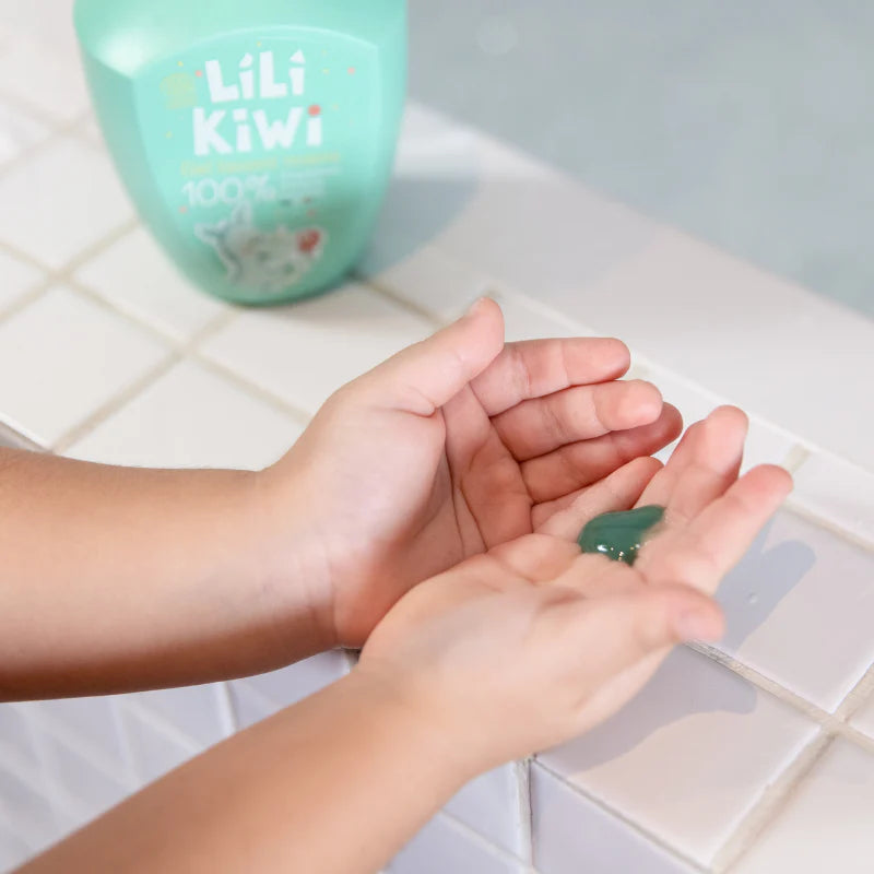 child applying green hand soap gel