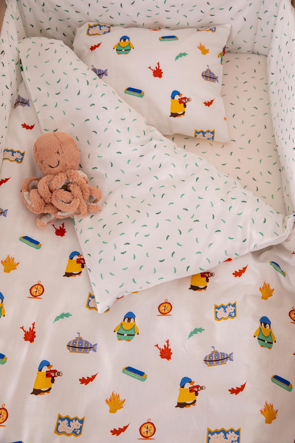 A kids duvet cover and pillowcase set with a pattern of illustrated penguins imprinted on it